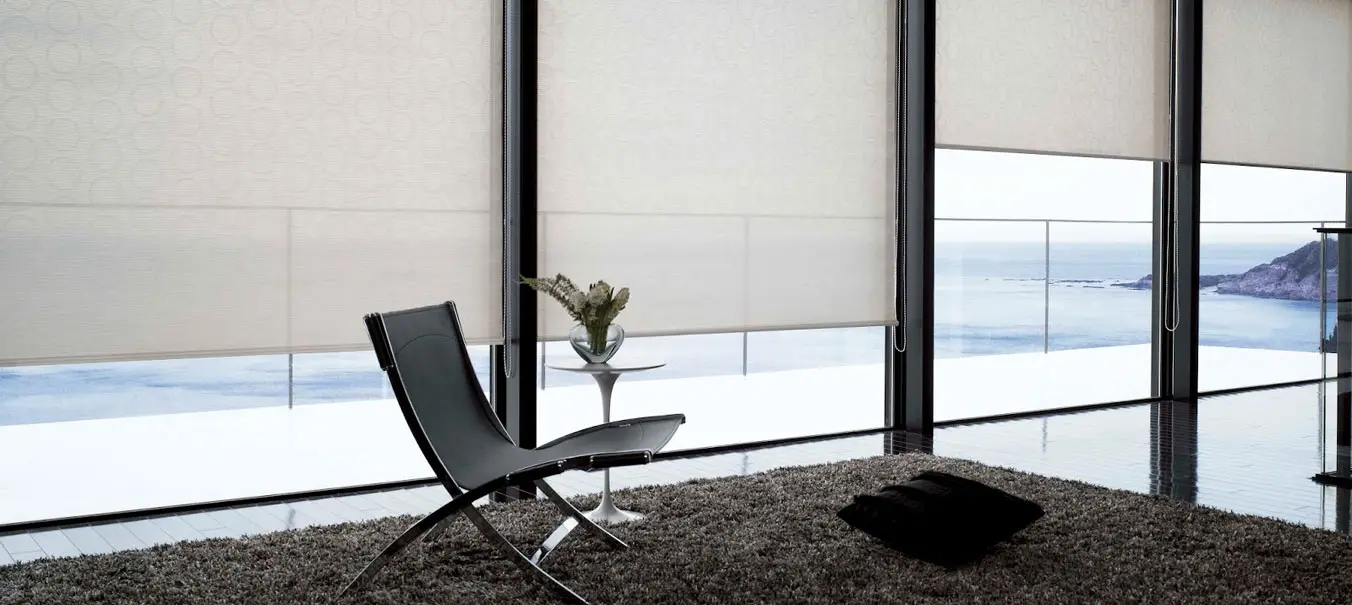 Estores enrollables con filtro de luz en un family room frente al mar
