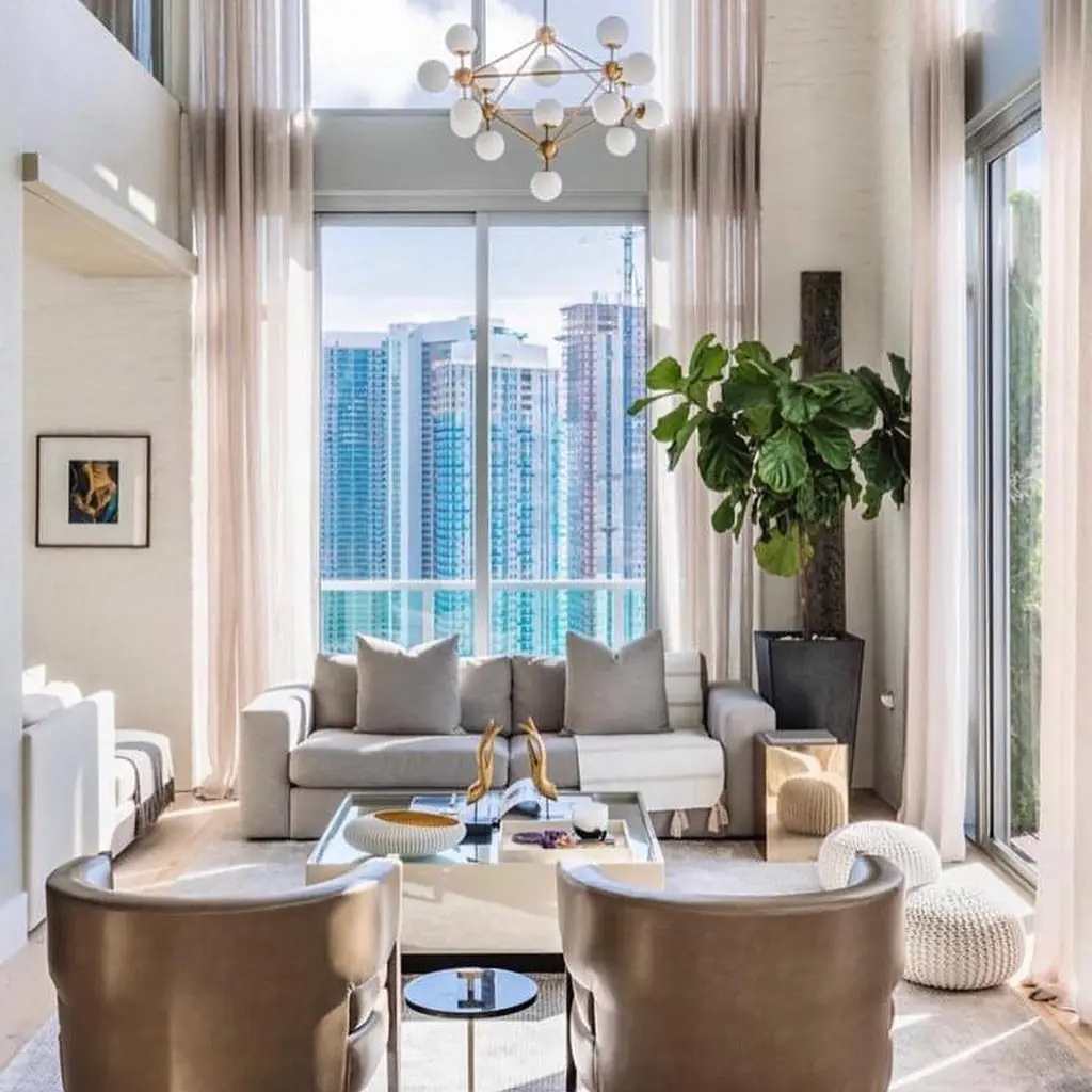 Floor-to-ceiling sheer drapery in a double-height Miami living room with skyline views